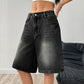 Angled view of the wide-leg denim shorts highlighting the drape through the thigh