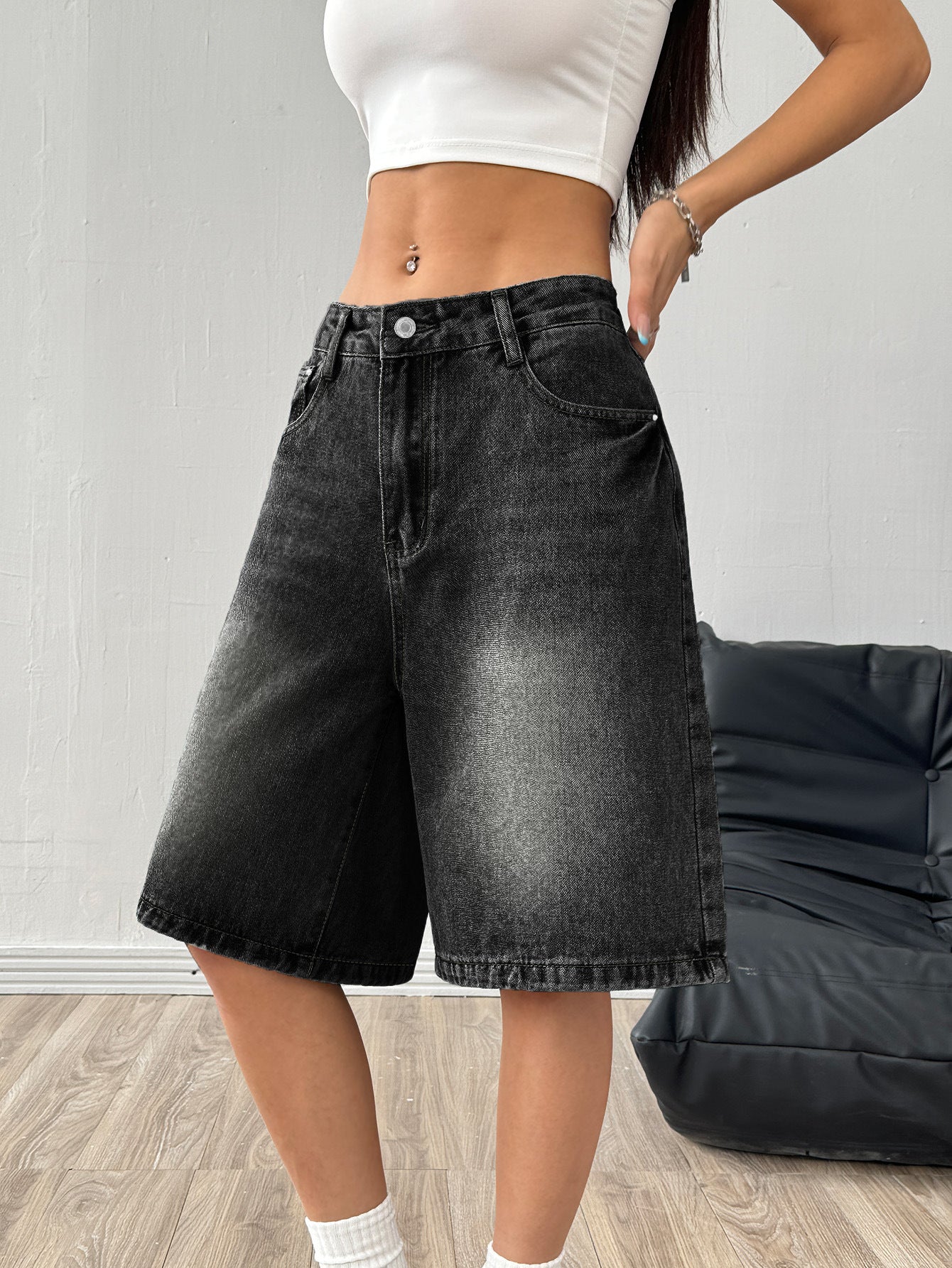Angled view of the wide-leg denim shorts highlighting the drape through the thigh