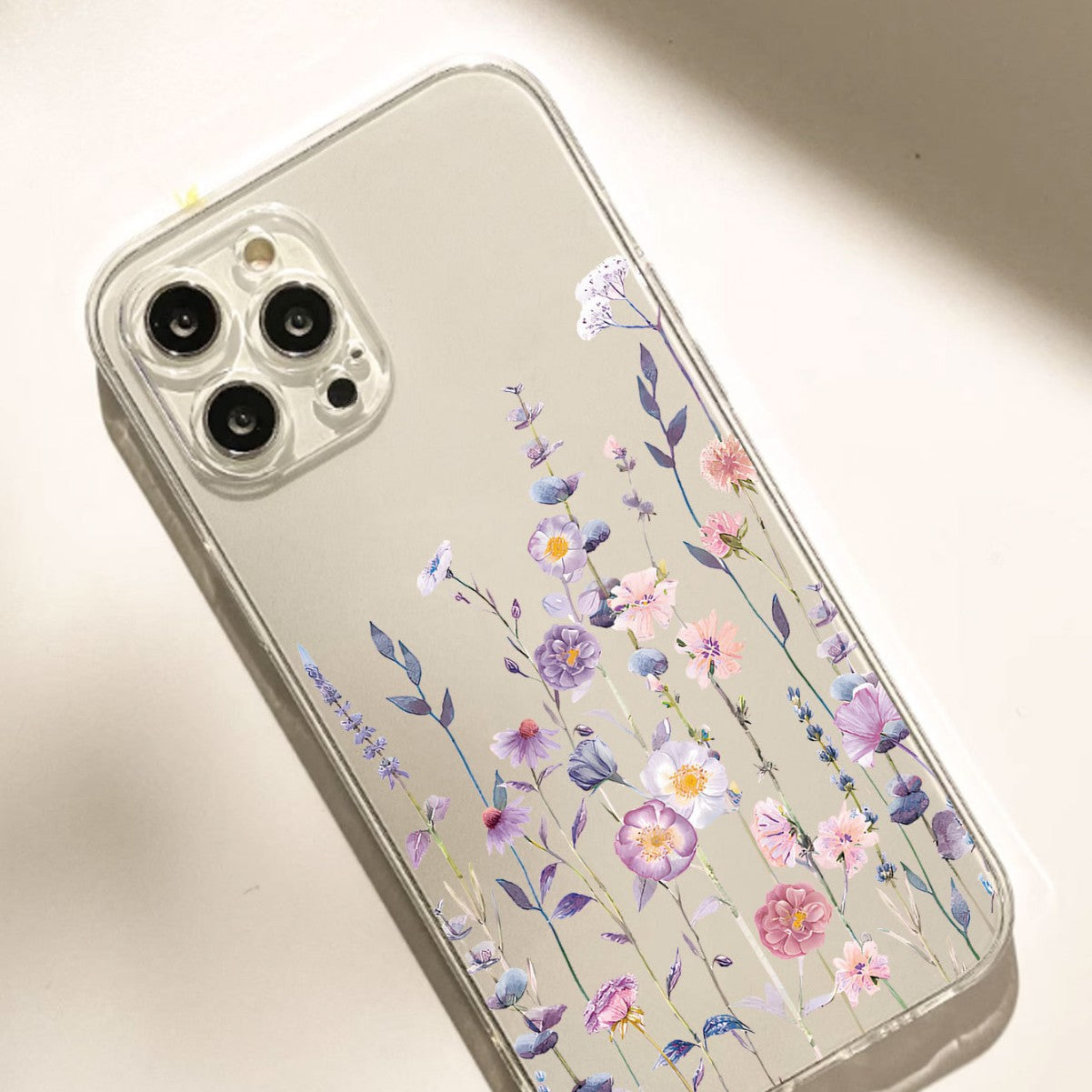 Purple and lilac wildflower print on a clear soft phone case
