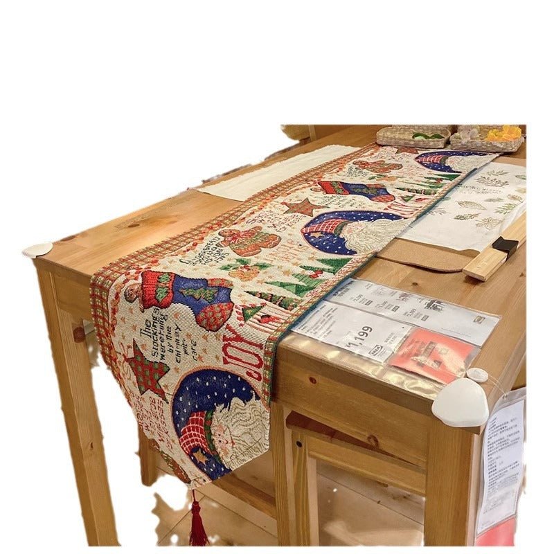 Table runner with stocking and moon pattern over a wooden table edge with a red tassel, not an option design