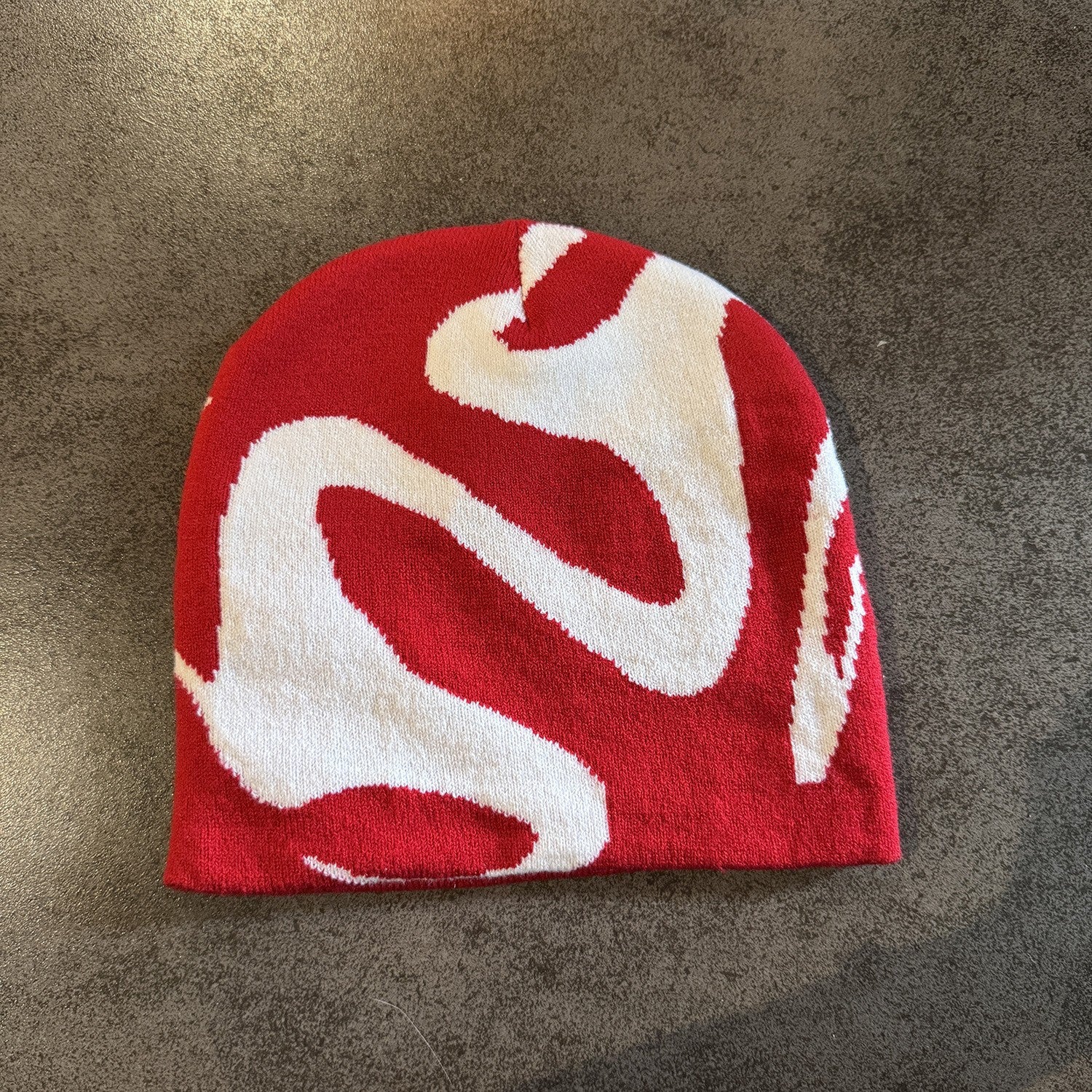 Red knit beanie with a contrast ghost fang pattern and high brimless crown