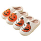 Cream plush slippers with tufted pumpkin designs on a white background