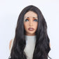 Close front view of a black wavy 13x4 lace front wig with a natural hairline and parting on a mannequin