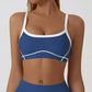 Front view of the sling strap sports bra with scoop neck and fine contrast piping on the bust