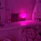 Pink heart night light casting a soft glow across a dim bedroom shelf