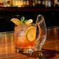 Novelty D cup cocktail glass filled with a layered orange sunset cocktail and orange slice