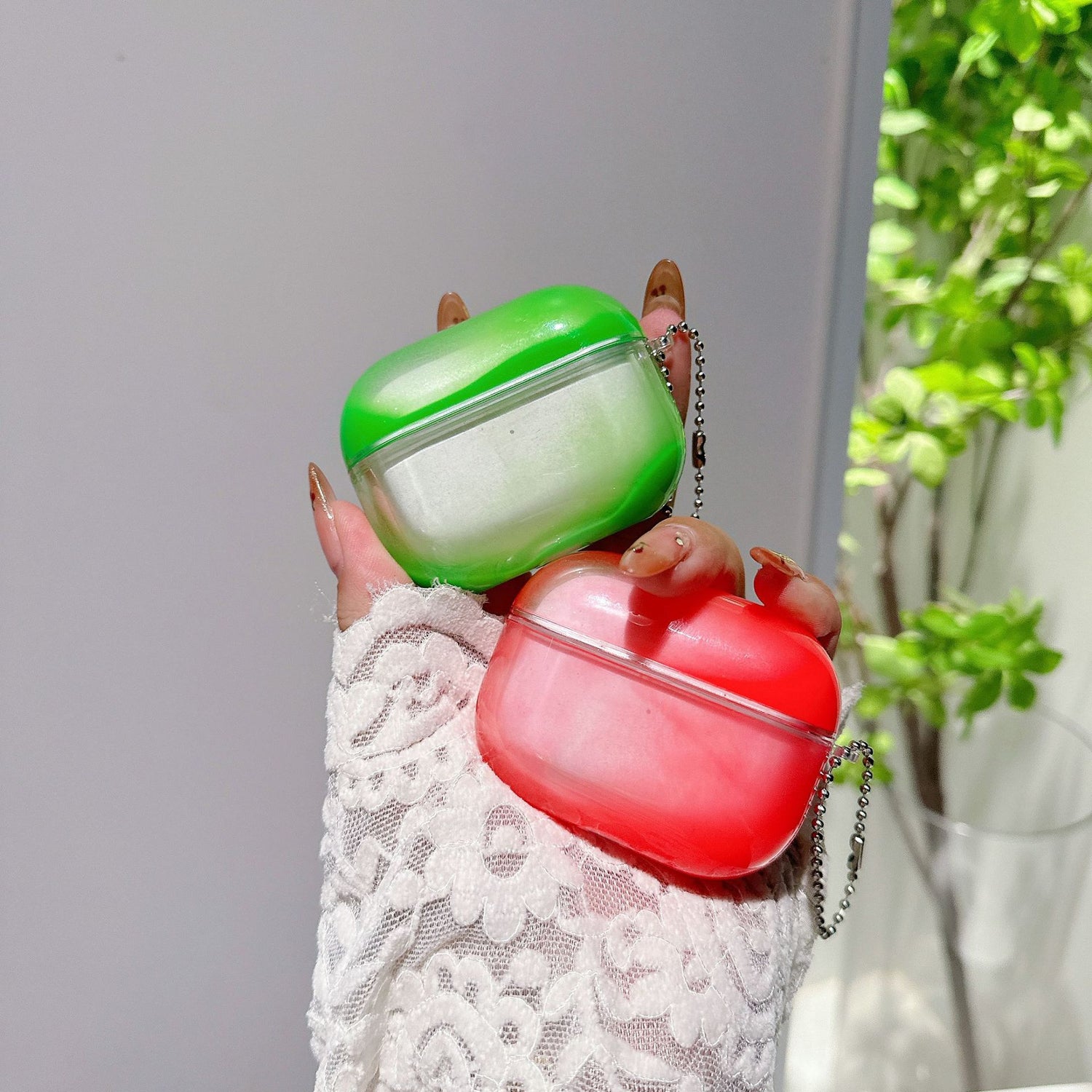 Blue two tone luminous AirPods cover held in hand with bead chain