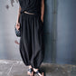Black balloon leg pants with an elastic gathered waist and gathered ankle cuffs