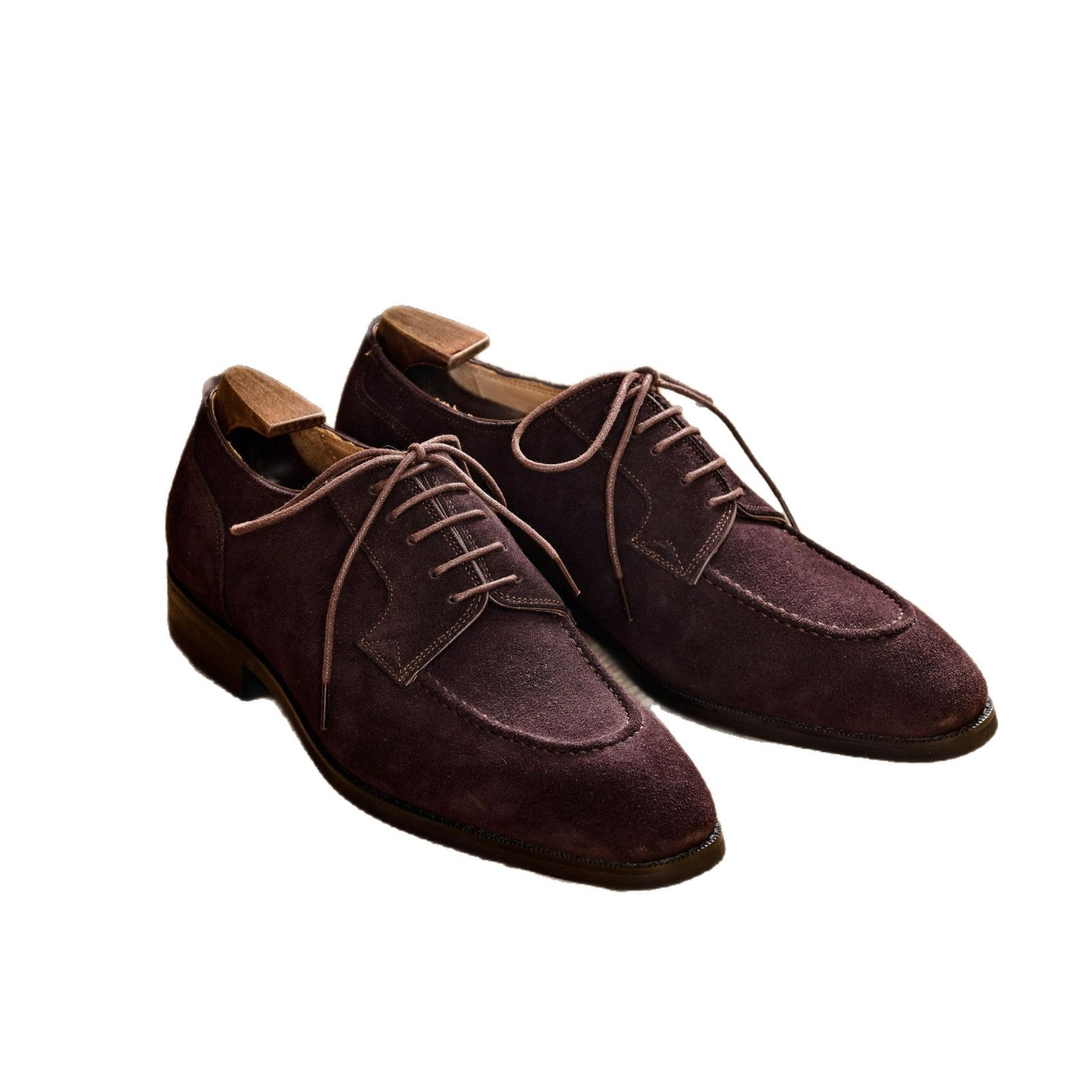 Pair of dark brown cowhide suede apron toe derby shoes on white, four eyelet open lacing and low heel