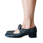 Dark blue Mary Jane shoe with buckle strap and low block heel, side view on a white background