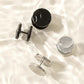 Black and steel disc barbell studs shown on a white surface, screw on backs visible