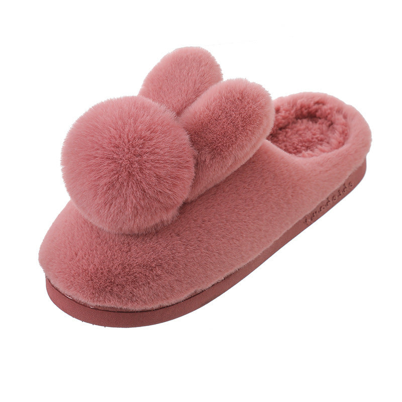 Single burgundy plush bunny slipper with two ears, a round pom pom and a thick sole on a white background