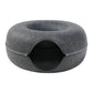 Two cats sharing a large beige felt donut tunnel bed on a wooden floor