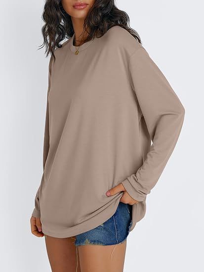 Khaki loose long sleeve rayon top with dropped shoulders worn with denim shorts, three quarter view