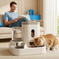 Pet owner on a sofa while a ginger cat eats from the white gravity feeder and water dispenser set