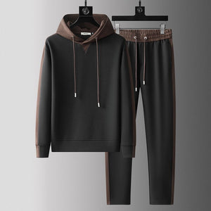 Side profile of the hooded tracksuit showing ribbed cuffs and drawstring joggers
