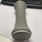 Grey nubbed foot roller standing upright on a desk beside a keyboard