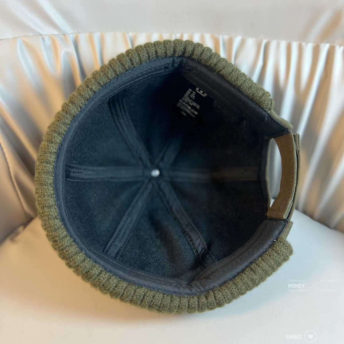 Khaki dome beanie with a ribbed knit cuff held in a hand