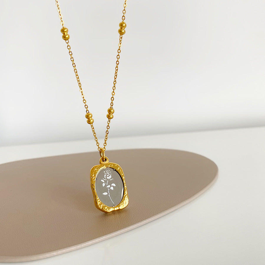 Stainless steel rose pendant with hammered gold frame and silver mirror center on a satellite chain