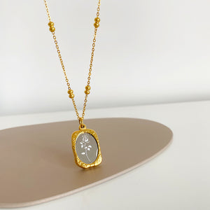 Stainless steel rose pendant with hammered gold frame and silver mirror center on a satellite chain