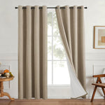 Linen look polyester blackout grommet curtain panel with white thermal backing hanging by a bright living room window