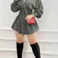 Gray button front mini shirt dress with smocked waist and long sleeves, with tall black boots and a red bag