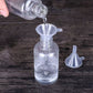 Mini plastic funnel set in a bottle neck while clear liquid is poured into it