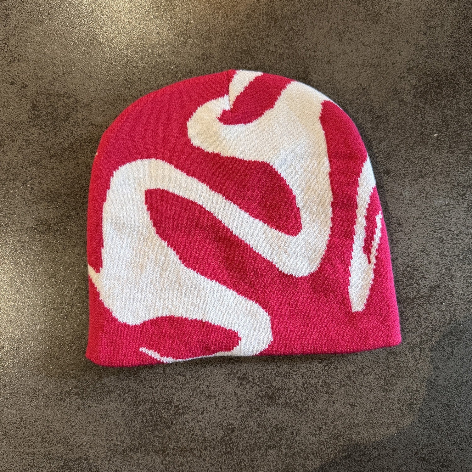 Acrylic knit ghost pattern beanie in magenta with a one size stretch fit