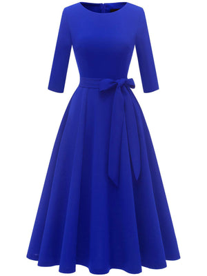 Blue vintage swing dress with round neck, bow belt and full pleated skirt, front view
