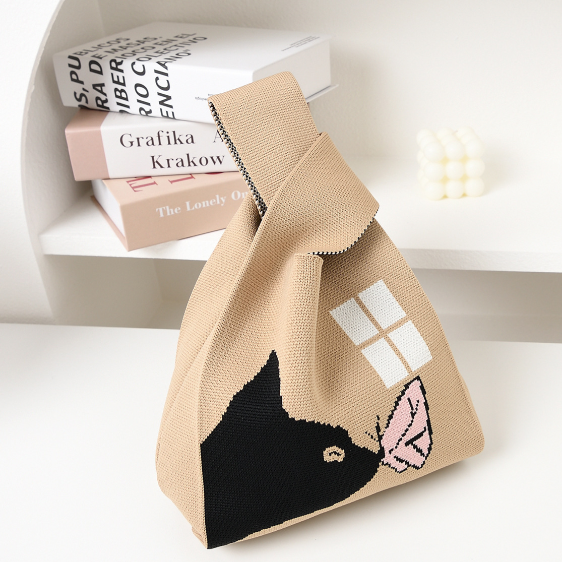 Soft knit wrist bag with an open top and a jacquard knitted pattern