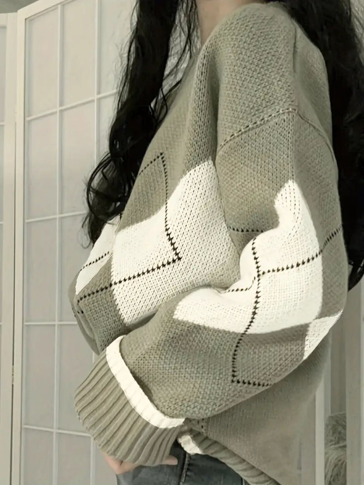 Cream and matcha green argyle sweater seen from the side, diamond panels across the chest and sleeve