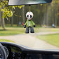 Masked horror figure acrylic ornament hanging from a car rear view mirror on a country road