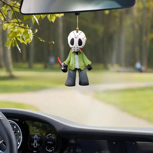Masked horror figure acrylic ornament hanging from a car rear view mirror on a country road
