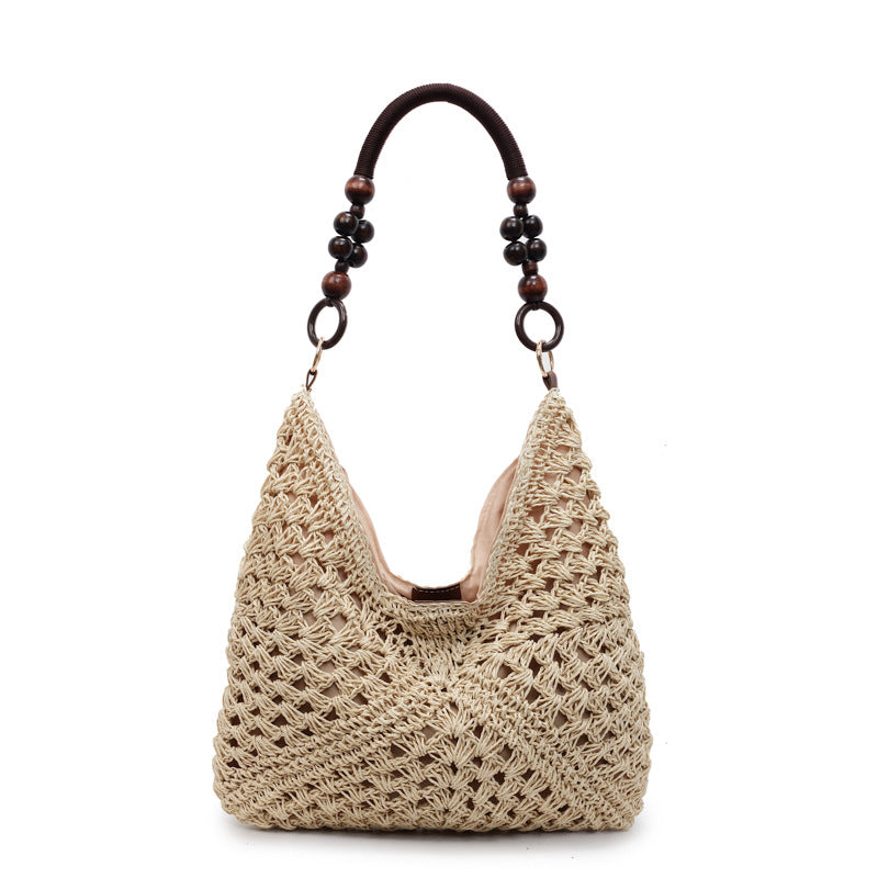 Khaki open-weave hobo bag with a dark cord and wooden bead handle on a plain white studio background