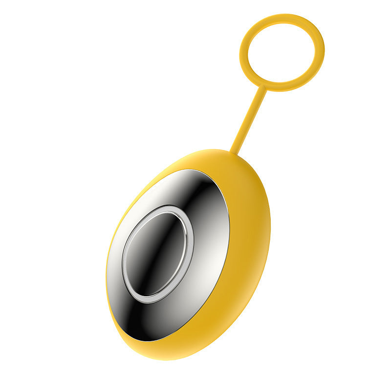 Yellow oval handheld sleep aid device with polished metal plate and silicone finger ring
