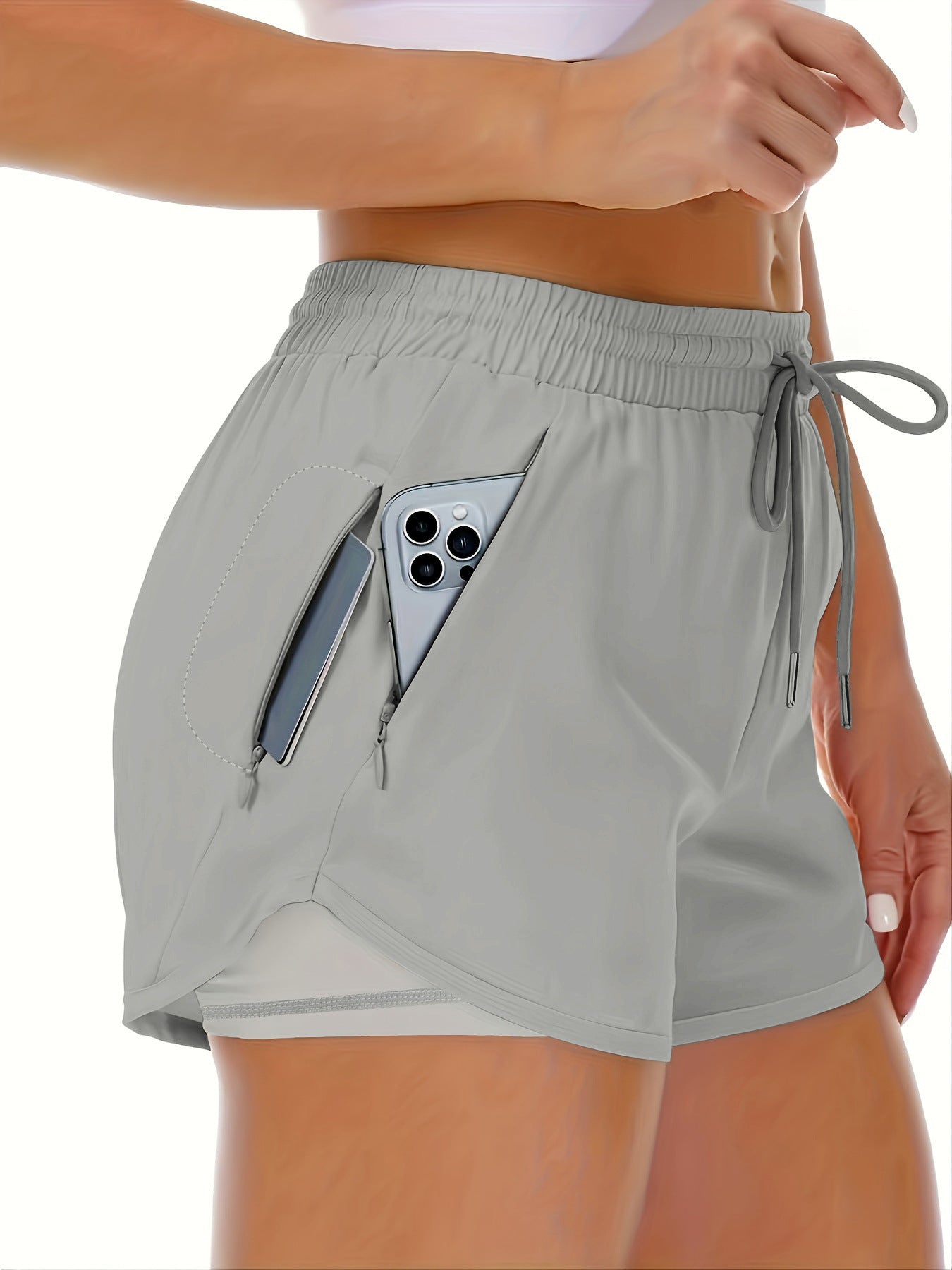 A fluorescent green side view of womens running shorts showing the phone pocket holding a phone