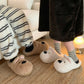 White puppy plush slippers beside a brown pair, worn with striped socks; only the white pair is offered