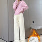 Woman in cream wide-leg drawstring pants and a pink sweater taking a mirror photo, fleece lining icon at lower right