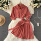 Shirt and skirt two-piece set laid out flat to show both garments