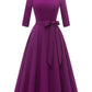 Close detail of the tie bow belt knotted at the waist of the vintage swing dress