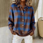 Woman in a brown plaid knit cardigan with bright blue check, shirt collar and white buttons, with a woven basket