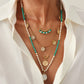 Gold layered bohemian necklace with turquoise beads and coin charms worn