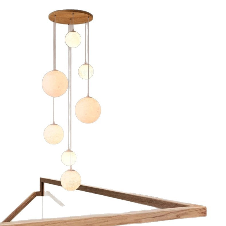 Cluster of glowing globe shades filling a double height stairwell