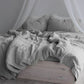 Washed cotton and linen blend bedding set in a soft solid color, styled on a made bed
