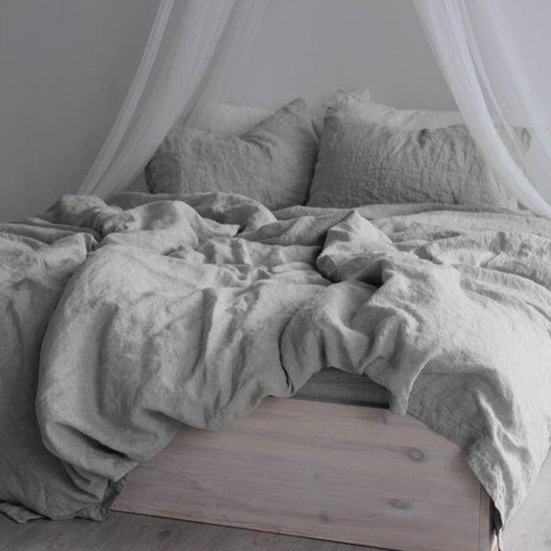 Washed cotton and linen blend bedding set in a soft solid color, styled on a made bed