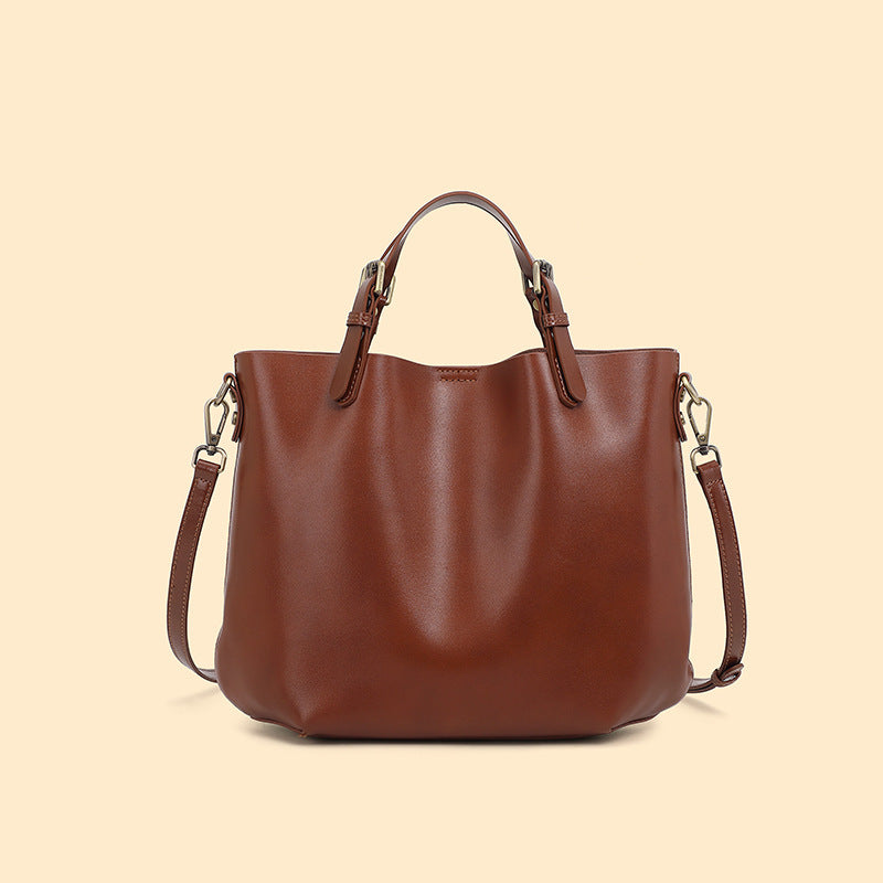Chestnut brown cowhide leather bucket tote with top handles and a shoulder strap, chestnut option