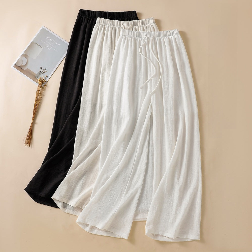 Linen blend wide leg trousers in white and black laid flat with drawstring waist