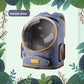 Denim blue space capsule cat carrier backpack with clear dome, side vents and tan piping on a leaf background