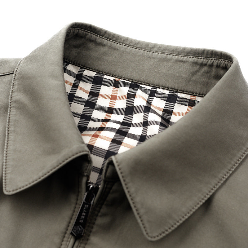 Close view of the turn-down collar and zipper of a khaki cotton jacket with a black and white plaid lining