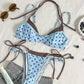 Red polka dot bikini flat lay with pink binding, triangle top above the tie side brief